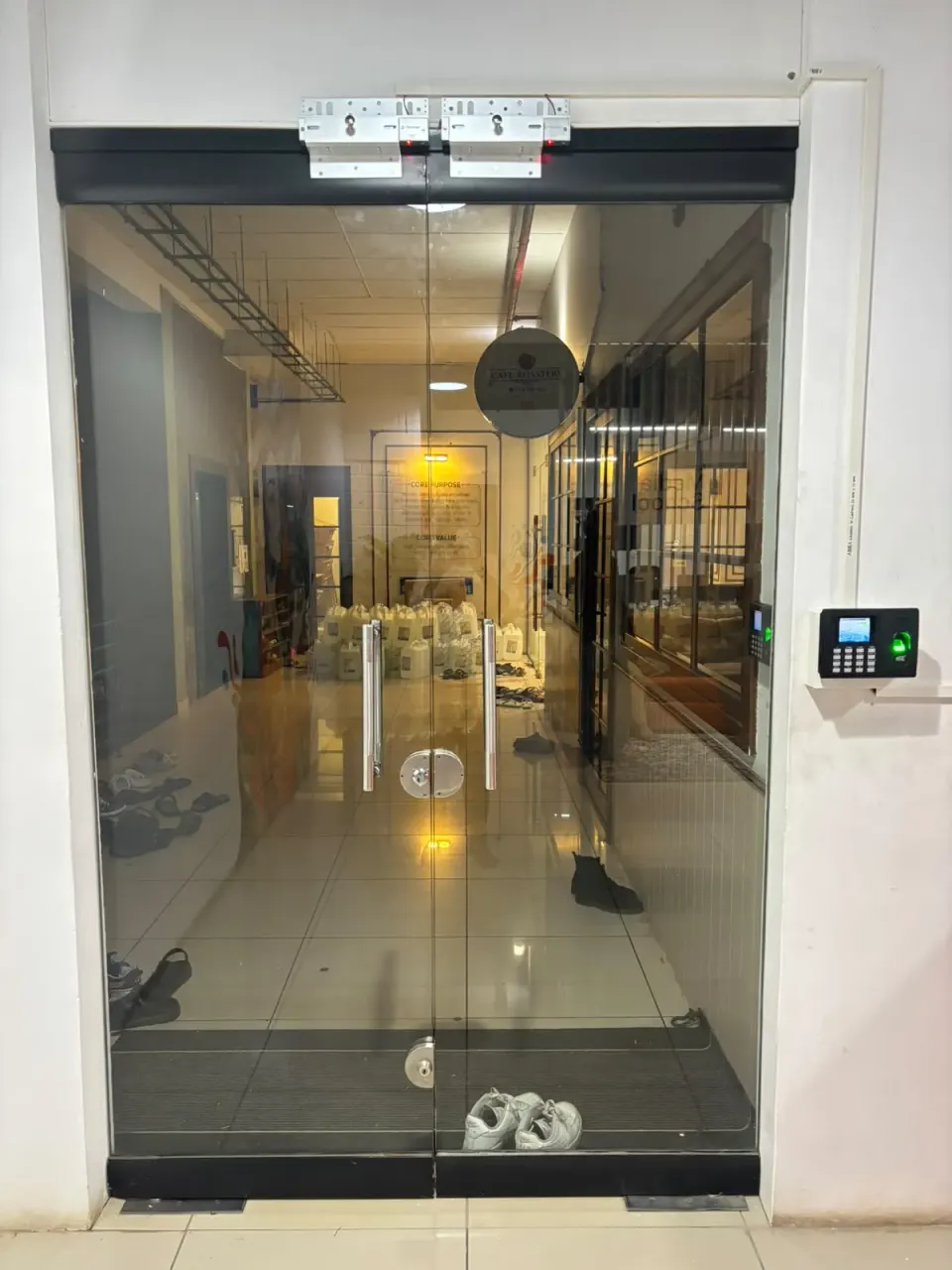 eSSL biometric access control reader beside the glass entrance doors at Bridgeon Media School